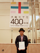 「大阪ミナミ400年祭」のロゴマークの最優秀賞に選ばれたデザイナーのクリオカイチロウさん